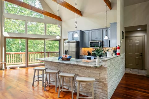 Spacious kitchen with large side windows offering serene outdoor views — perfect for cooking and gathering.