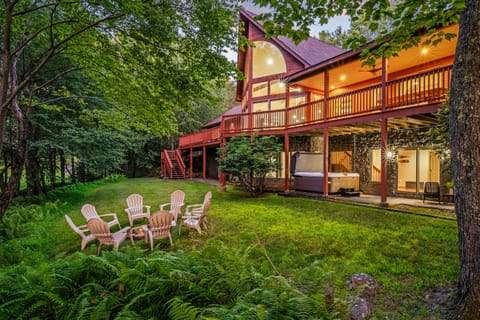 Spacious backyard with lush greenery, a cozy fire pit, and a relaxing hot tub.