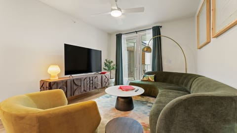 Stretch out in the inviting living room with a plush sofa, oversized TV, and modern design touches throughout.