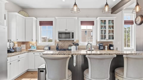 Modern kitchen with breakfast bar and pendant lighting.