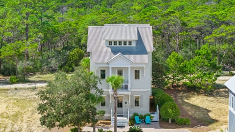 Front exterior of the home surrounded by lush greenery.
