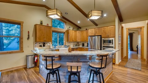 Modern kitchen with barstool seating and stainless steel appliances.