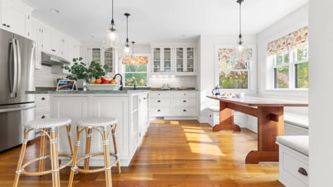 White kitchen with barstool seating and breakfast nook.