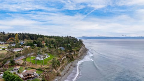 Bright living room with a TV, floor-to-ceiling windows, and ocean view.