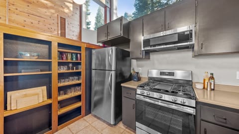 Fully equipped kitchen with stainless steel appliances and wood cabinetry.