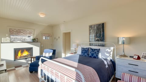 The primary bedroom features a queen bed, a fireplace, and comfortable seating.