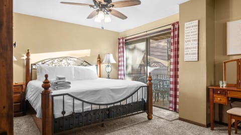 Primary bedroom features a king bed, ceiling fan and balcony access.
