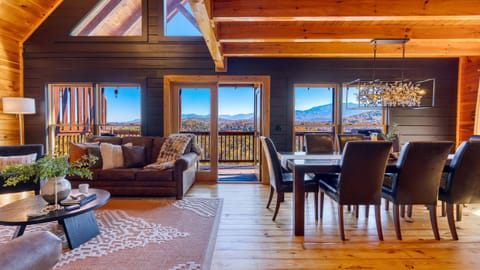 Bright, open living and dining space with soaring ceilings, cozy seating, and unbeatable panoramic mountain views.