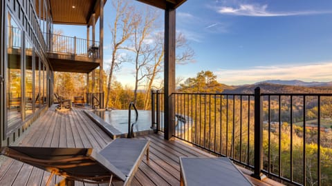 Bright open-concept living area with floor-to-ceiling windows framing panoramic Smoky Mountain views.