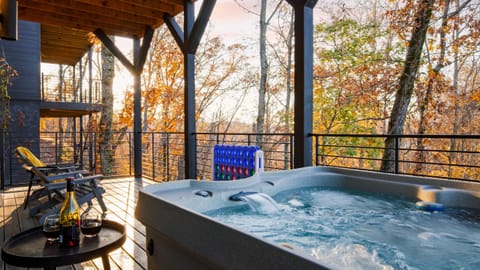 Balcony with hot tub, seating, and views.