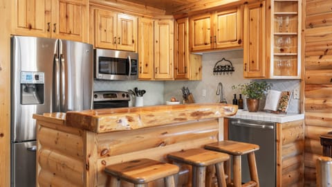 Kitchen with barstool seating and modern appliances.