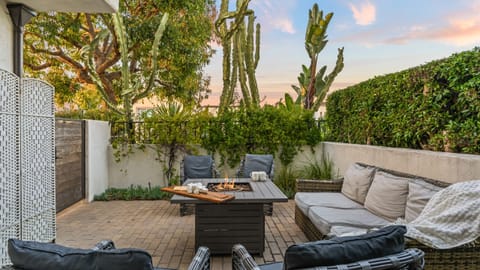 Patio lounge with cushioned seating and firepit.