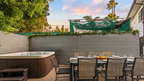 Private patio with hot tub, al fresco dining table, and privacy wall.