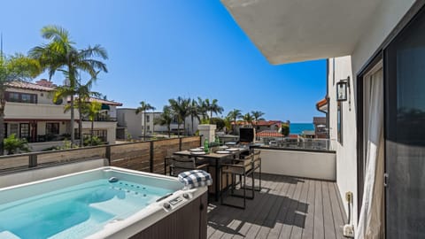 Soak in the sunshine from your private deck, complete with a bubbling hot tub, grill, and peek-a-boo ocean views. (Unit 2)