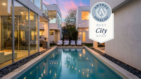 Golden-hour glow over a modern oasis with poolside lounges and cozy firepit seating.