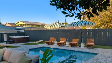 Pool area with sun loungers and umbrellas.
