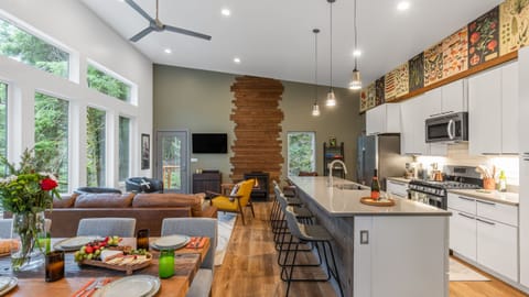 Open-concept living room, kitchen, and dining area with vaulted ceilings.