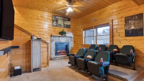 Home theater/media room with reclining seats and a fireplace.
