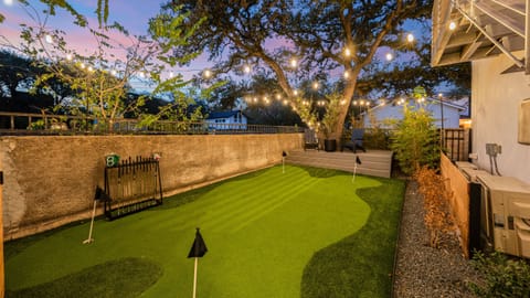 Enjoy the shared putting green under glowing string lights for a relaxing evening activity.