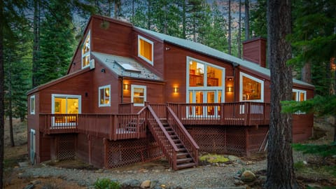 Warm cabin light meets towering pines—your perfect Tahoe retreat awaits.
