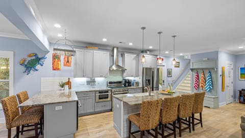 Kitchen view showing the full layout and breakfast bar with barstools.