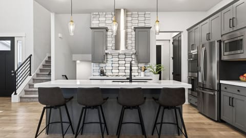 Sleek, chef-style kitchen with a spacious waterfall island, premium stainless appliances, and seating for casual meals or après-ski gatherings.