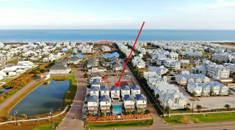 Aerial view showing the homes, the pond, and the ocean.