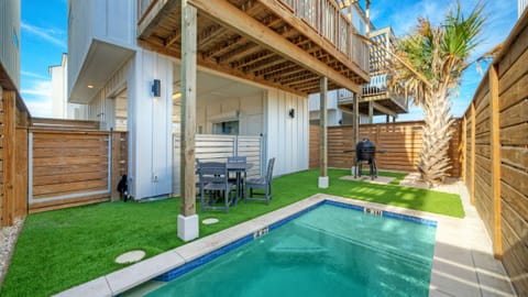 Private backyard featuring a small plunge pool, patio furniture, BBQ grill, and artificial turf.