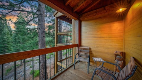 Rustic balcony seating under exposed wood beams, offering a serene spot to take in the fresh Tahoe air.