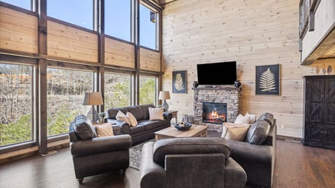 Bright and spacious living area with a fireplace and a TV.