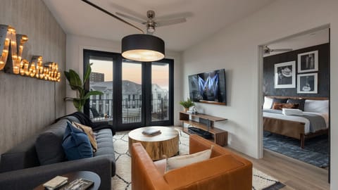 Sun-drenched living space with modern furniture, hardwood floors, and balcony access.