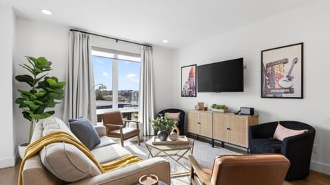 A bright, inviting living area with a queen sleeper sofa and large windows that bring in natural light.