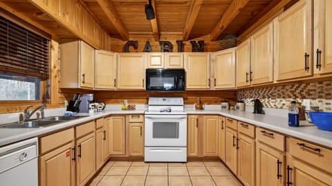 Fully equipped kitchen with wrap-around cabinetry and modern white appliances.