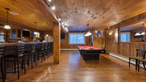 Elegant in-home bar with a pool table for evening drinks and effortless entertaining.