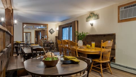 Dining area with multiple wooden tables and natural light.