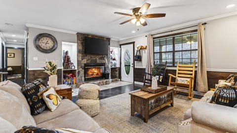 Warm up indoors in this inviting living room, where a stone fireplace, plush seating, and rustic details set the tone for cozy mountain nights.