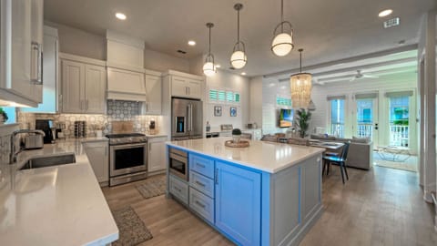 Modern kitchen featuring a large blue island and white cabinetry.