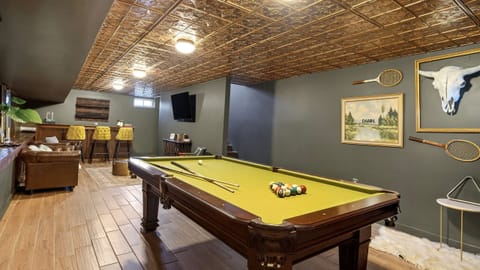 Lower-level game room with pool table, bar seating, and lounge area.