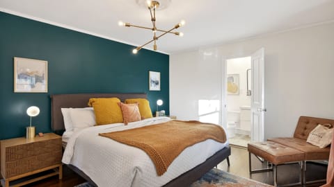 The primary bedroom features a king bed, sleek leather seating and an ensuite bathroom.