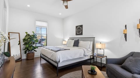 Primary bedroom features a king bed with a ceiling fan, a modern design, and an attached full bathroom.