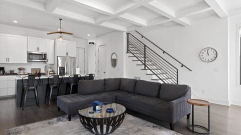 Living room view highlighting the sleek black metal staircase and open floor plan