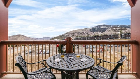 Private balcony with a bistro set overlooking the mountain landscape.