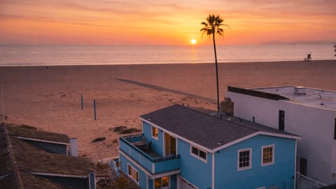 Elevated sunset view of a boardwalk-front beach house just steps from the sand.