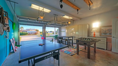 Game-on garage with ping pong, foosball, bar seating, and plenty of space to hang out—perfect for friendly competition and laid-back evenings.