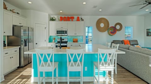 Spacious coastal kitchen with a large island, bar seating, and bright open layout—ideal for casual meals and gathering with the whole group.