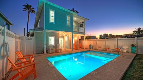 Twilight poolside vibes with glowing lights, lounge seating, and a private backyard—perfect for relaxed Port A evenings.