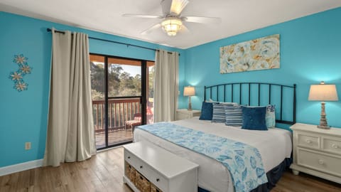 The primary bedroom features a king bed, en-suite vanity, TV, and private balcony access.