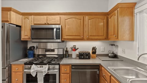 A fully-equipped chef’s kitchen featuring stainless steel appliances and ample prep space.