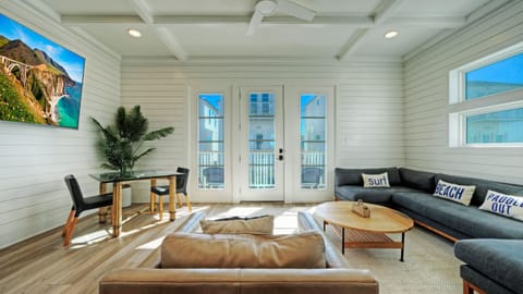 Bright, open-concept living area with balcony access and relaxed coastal style.