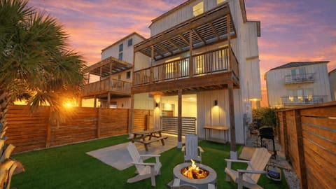 Private fenced backyard with firepit, outdoor seating, and covered patio.